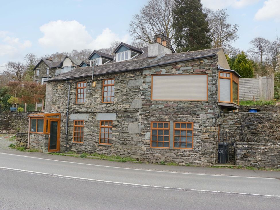 A stone building with windows and door at Wilders Wood Windermere