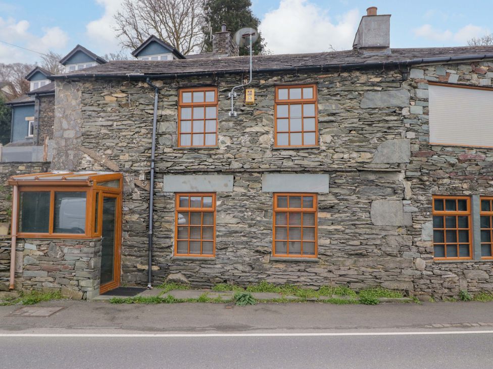 An exterior view of a stone house with multiple windows at Wilders Wood in Windermere