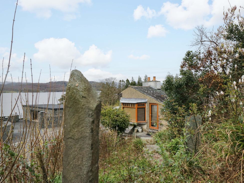 A house near water with trees and bushes at Wilders Wood in Windermere