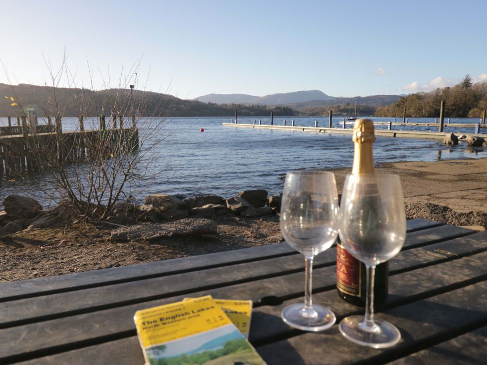 A table with champagne and two glasses overlooking the lake at Wilders Wood Windermere