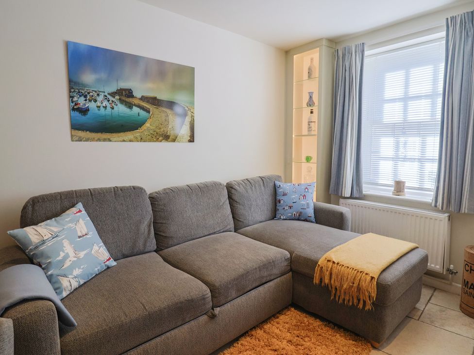 A living room with a sofa and a picture on the wall at Phoenix Cottage in Lyme Regis
