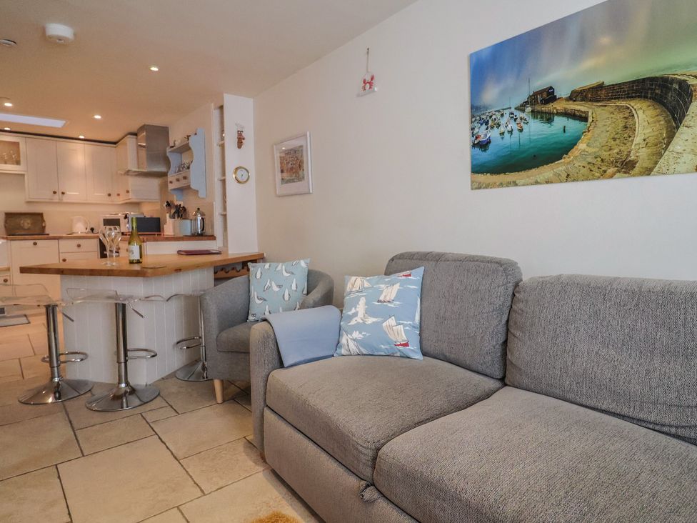 A living room with a sofa and dining area at Phoenix Cottage in Lyme Regis