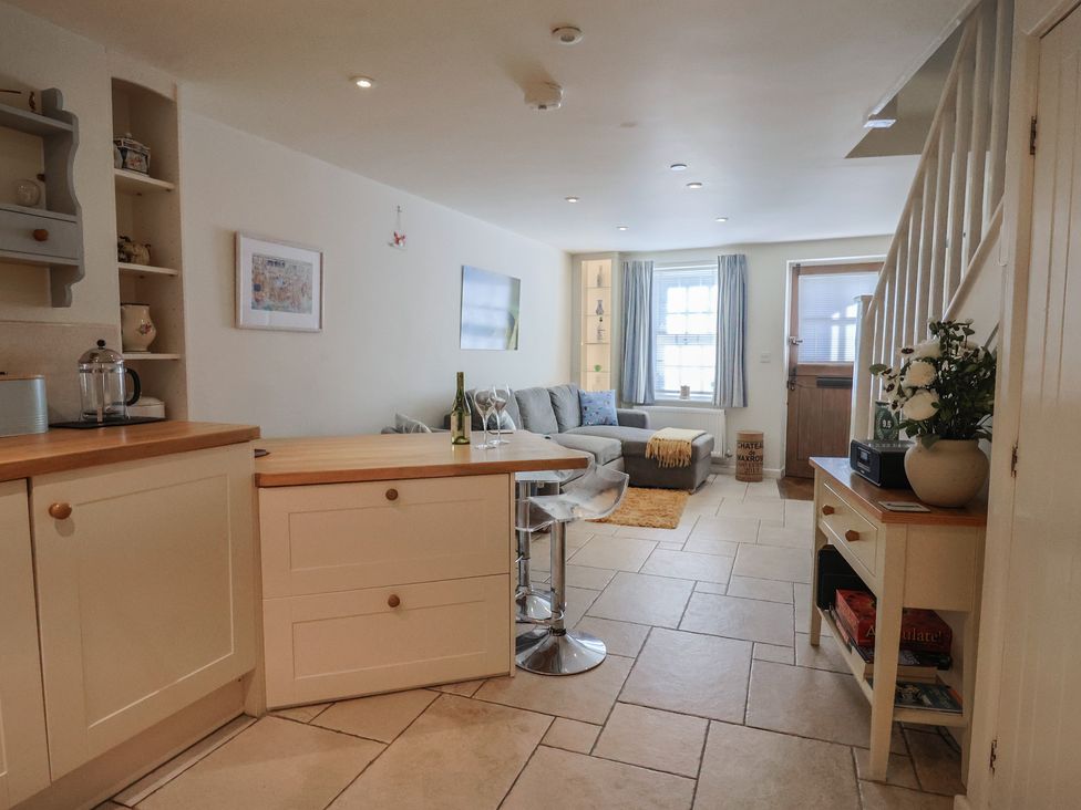 A living room with a couch and dining table at Phoenix Cottage in Lyme Regis