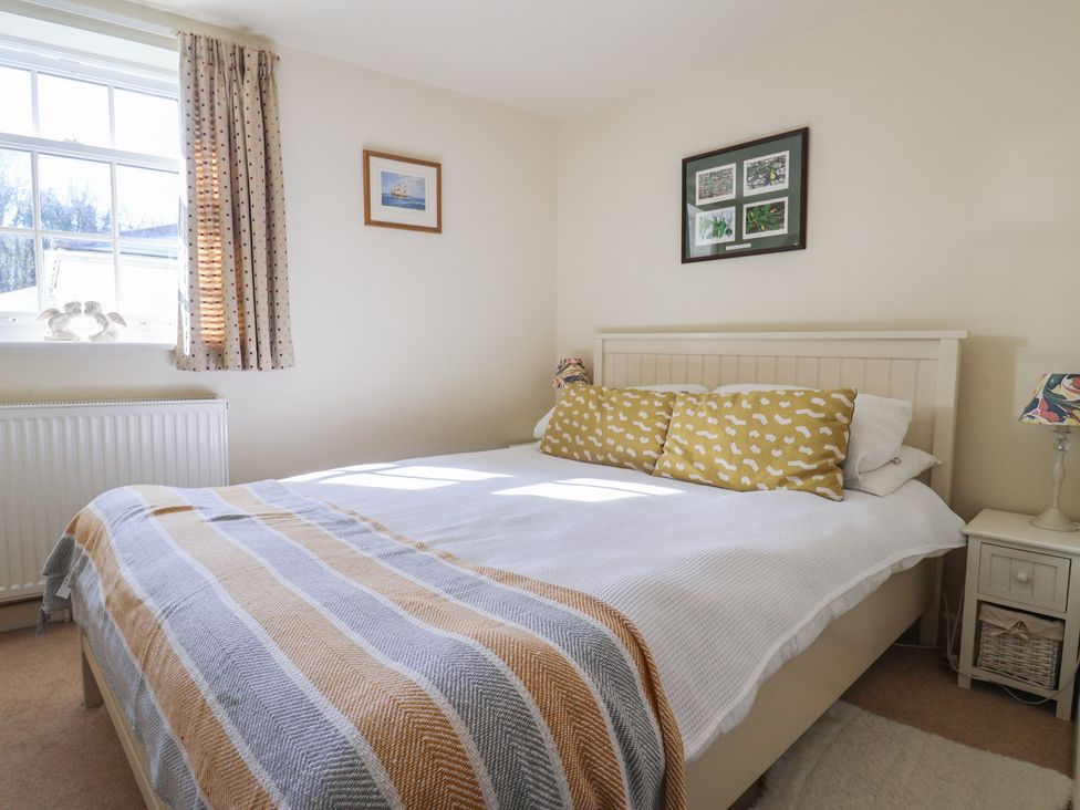 A bedroom with a bed and bedside table at Phoenix Cottage in Lyme Regis