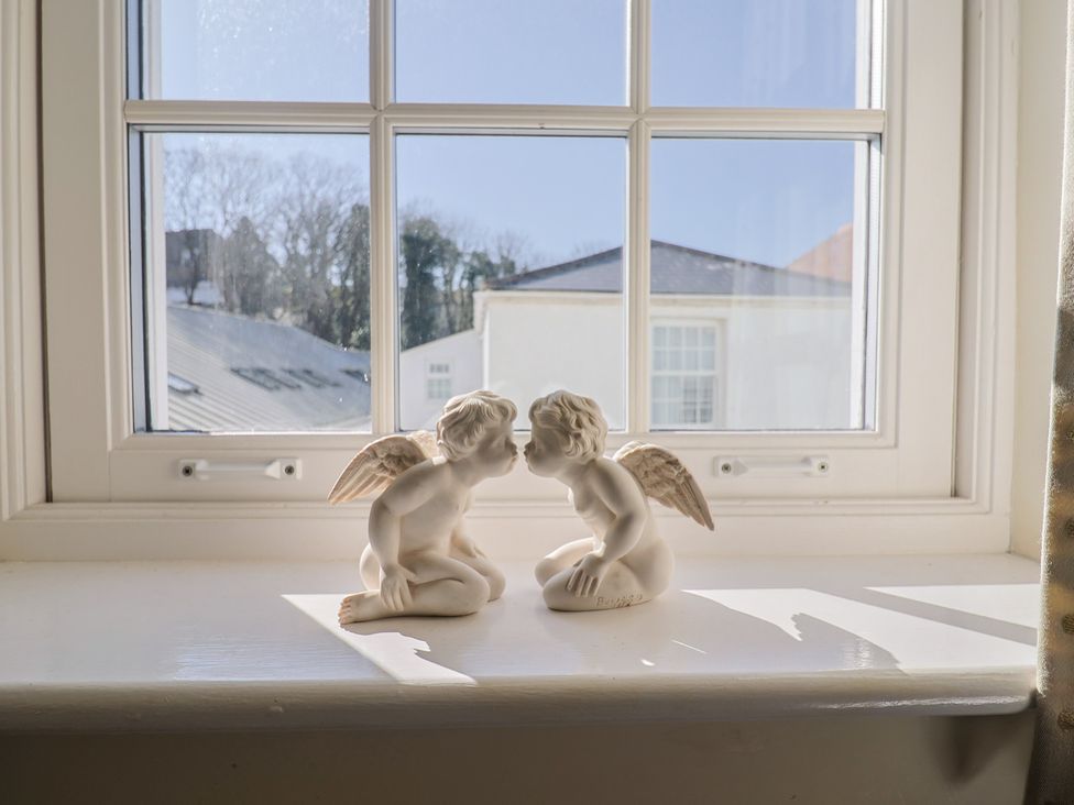 Two figurines on a window sill at Phoenix Cottage in Lyme Regis