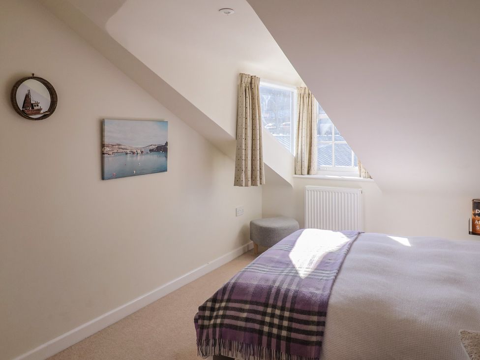A bedroom with a bed and window at Phoenix Cottage in Lyme Regis
