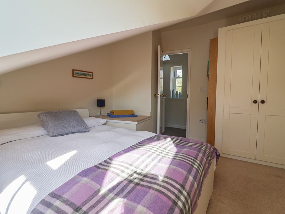 A bedroom with a bed and wardrobe at Phoenix Cottage in Lyme Regis