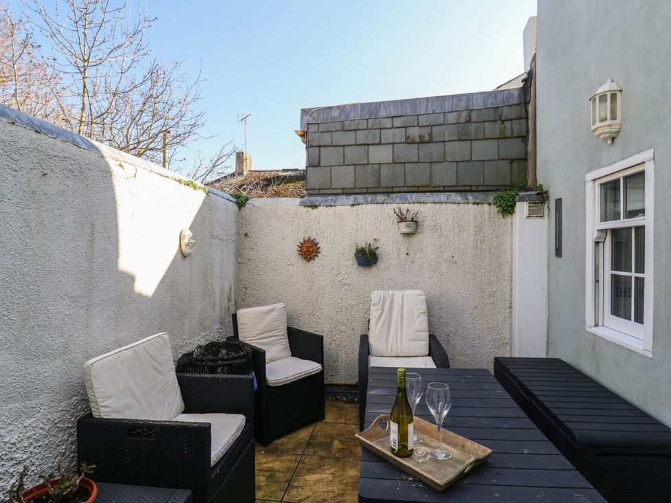 A garden with outdoor seating and a table at Phoenix Cottage in Lyme Regis
