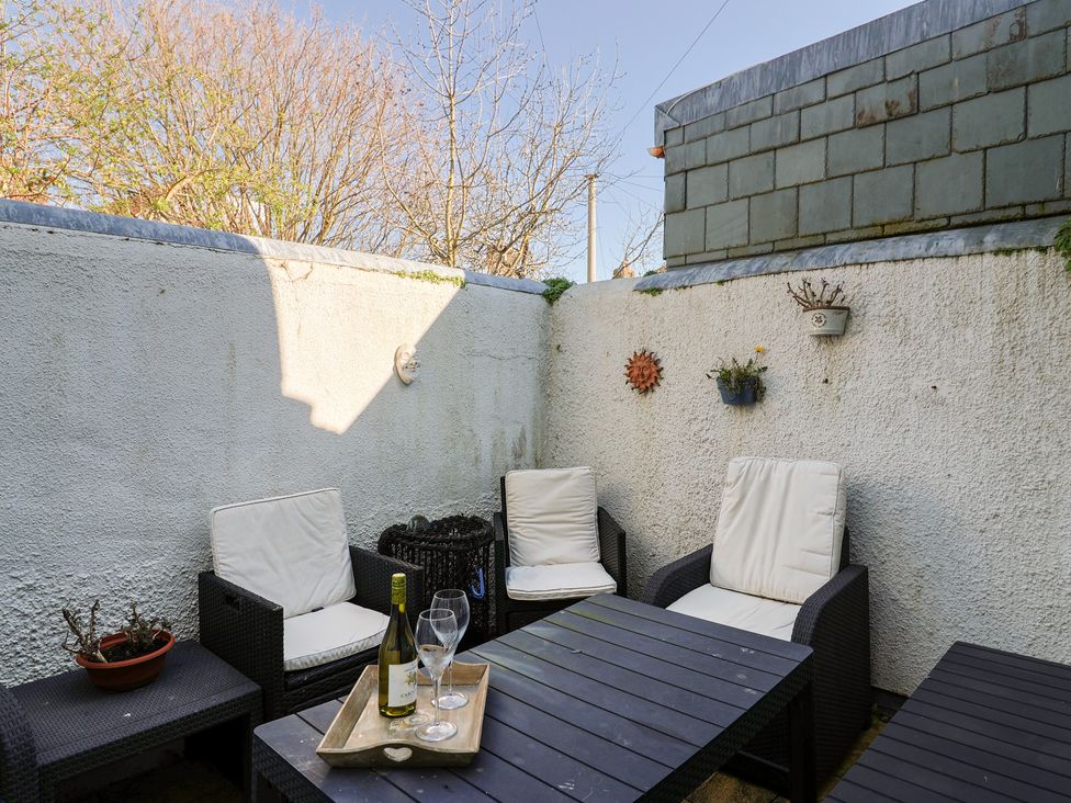 An outdoor patio with seating and a table at Phoenix Cottage in Lyme Regis