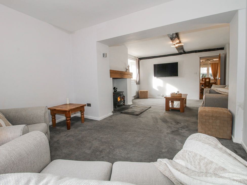 A living room with a sofa, coffee table, and television at Corner House in Minsterley