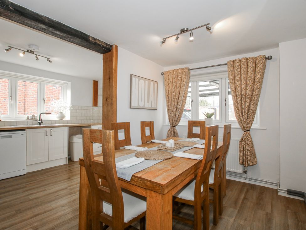 A dining room with a wooden table and chairs at Corner House in Minsterley