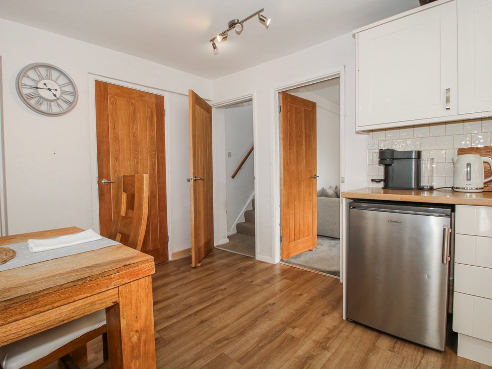 A kitchen with a fridge and a wooden table at Corner House in Minsterley