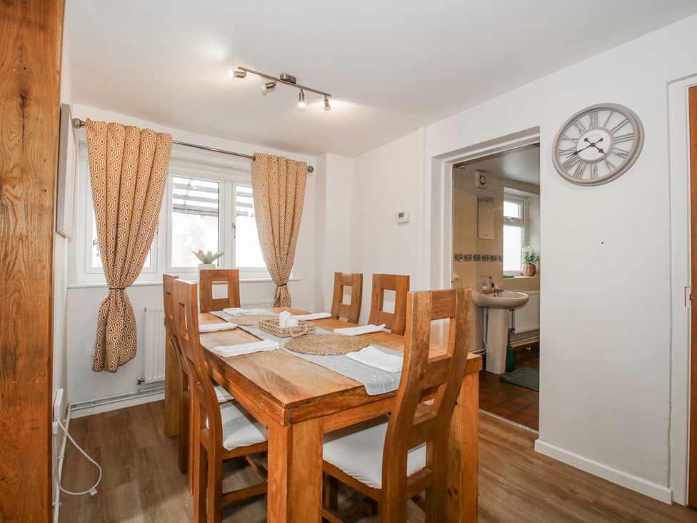 A dining room with a wooden table and chairs at Corner House in Minsterley