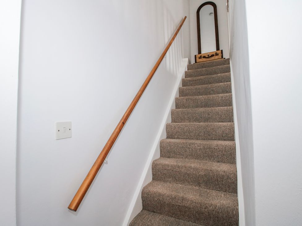 A staircase with a handrail and mirror at Corner House in Minsterley