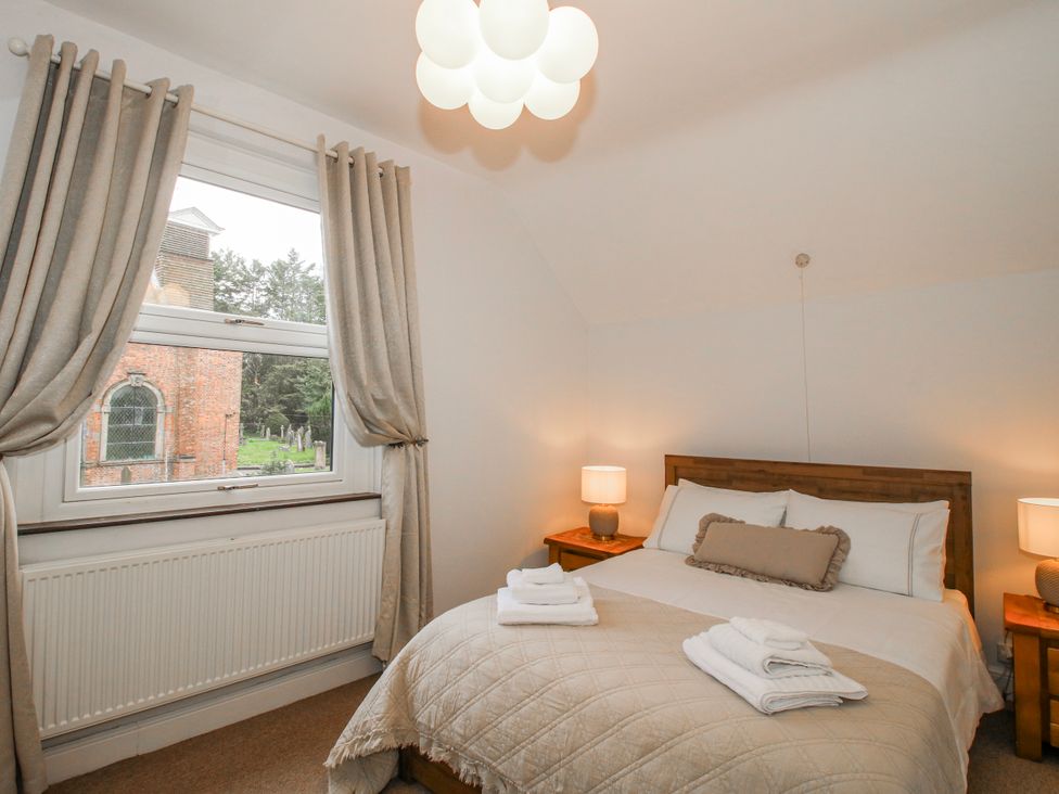 A bedroom with a bed and two lamps at Corner House in Minsterley