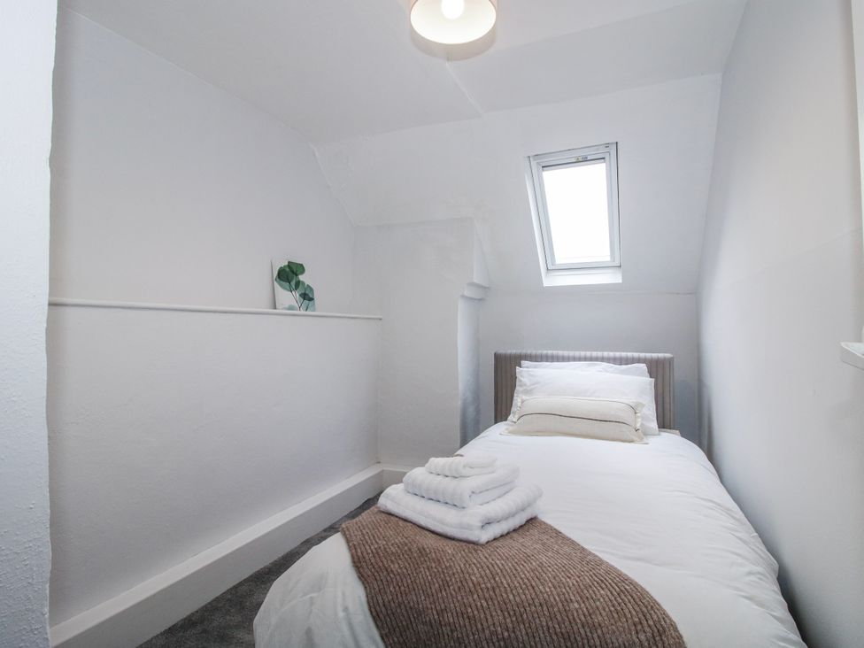 A bedroom with a single bed and towels arranged at Corner House in Minsterley