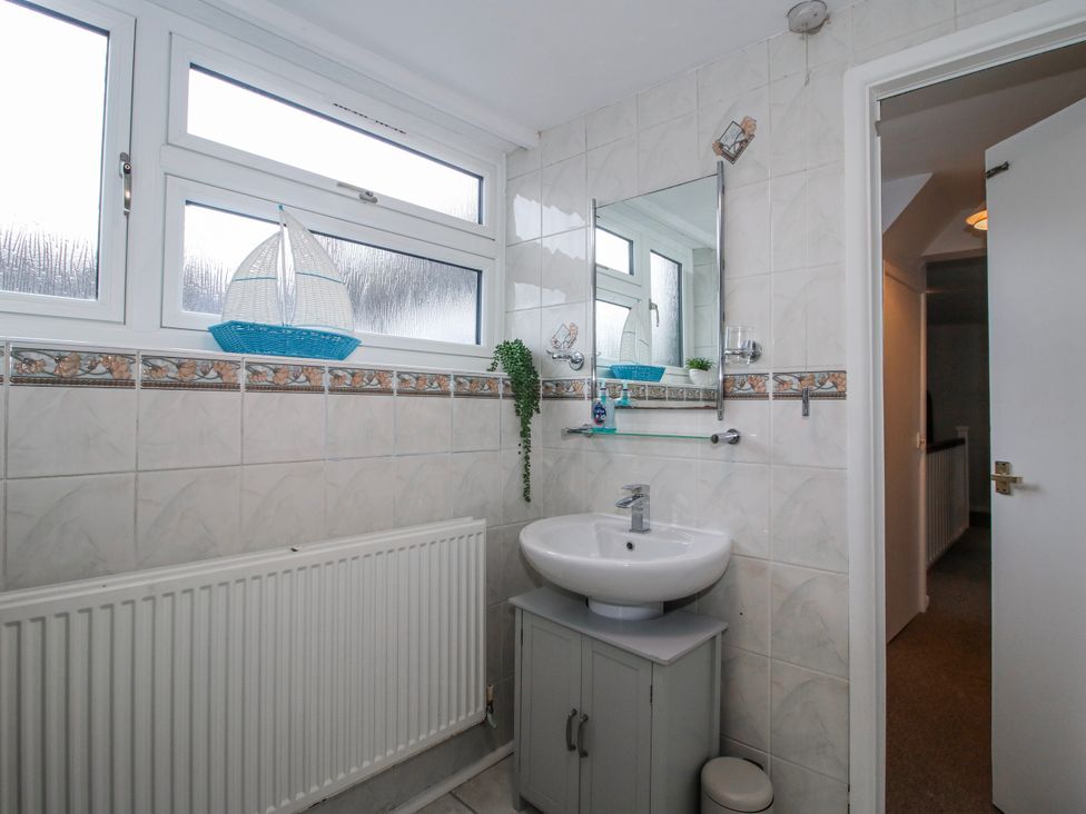A bathroom with a sink and mirror at Corner House in Minsterley