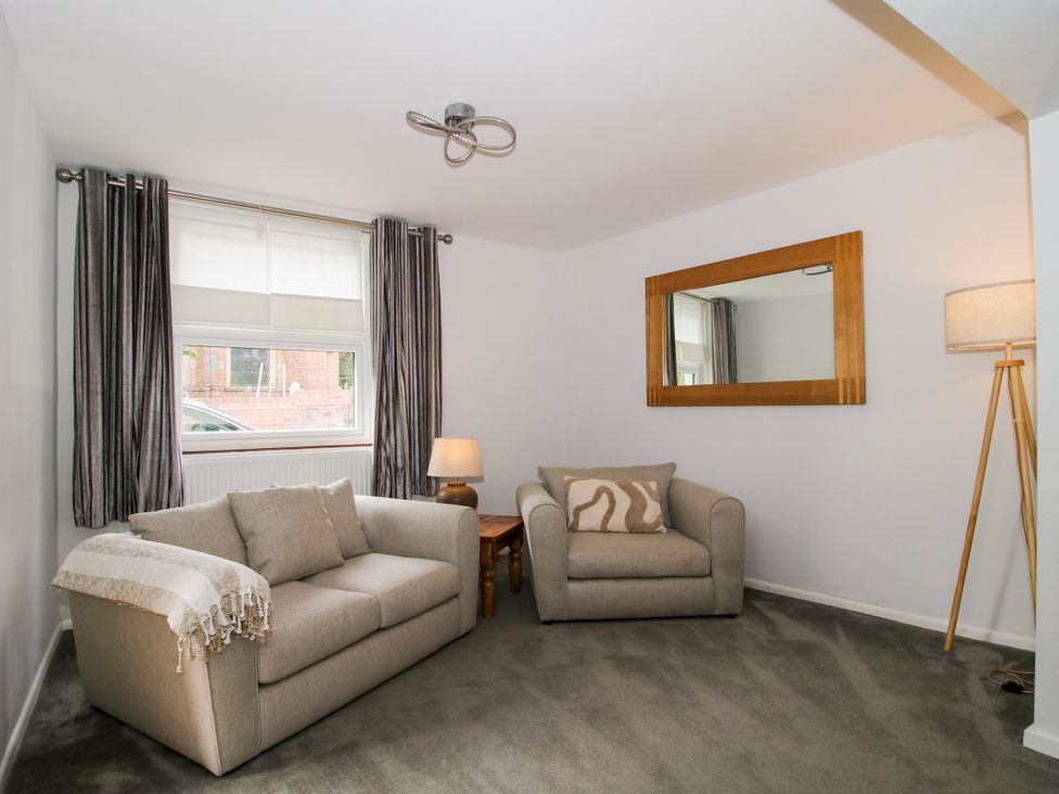 A living room with a sofa and armchair at Corner House Minsterley