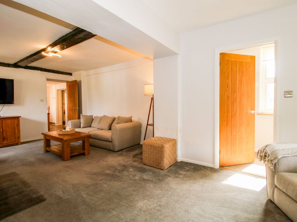 A living room with a sofa and television at Corner House in Minsterley
