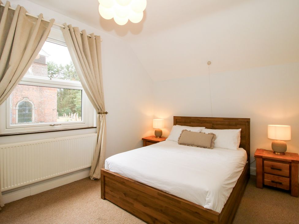 A bedroom with a bed and nightstands at Corner House Minsterley