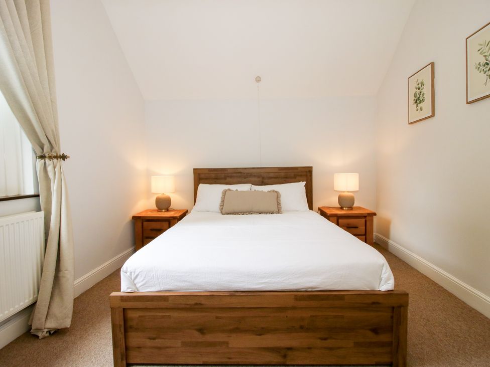 A bedroom with a bed and nightstands at Corner House Minsterley