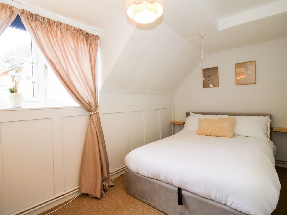A bedroom with a bed and curtains at Corner House in Minsterley