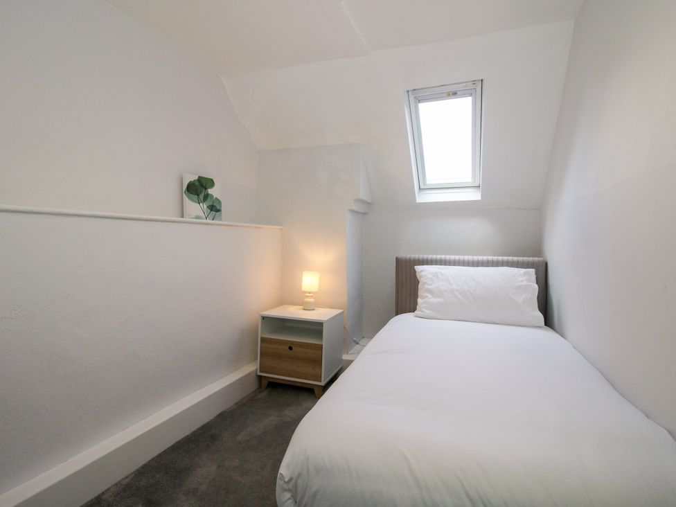 A bedroom with a bed and a nightstand at Corner House in Minsterley