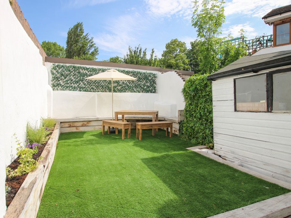 A garden with a table and chairs under an umbrella at Corner House in Minsterley
