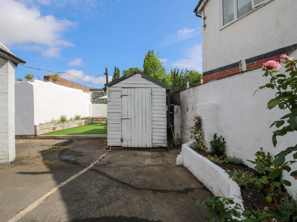 A garden with a shed and grass area at Corner House Minsterley