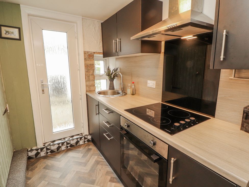 A kitchen featuring a sink, oven, and cooktop at 25 Low Seaton in Workington
