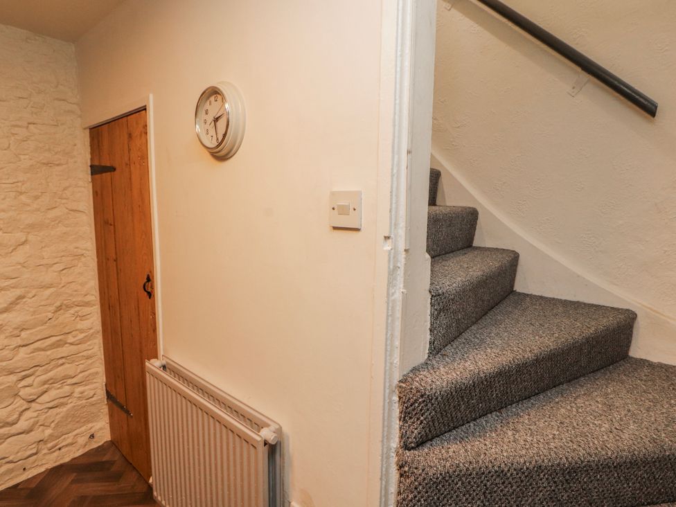 A hallway with a staircase and clock at 25 Low Seaton Workington