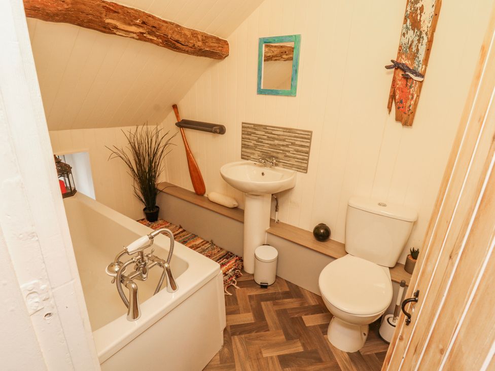 A bathroom with a bathtub, toilet, and sink at 25 Low Seaton in Workington