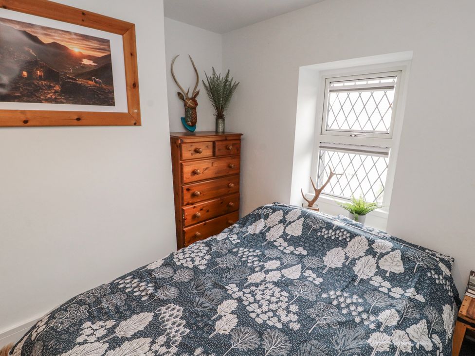 A bedroom with a bed and a wooden dresser at 25 Low Seaton in Workington