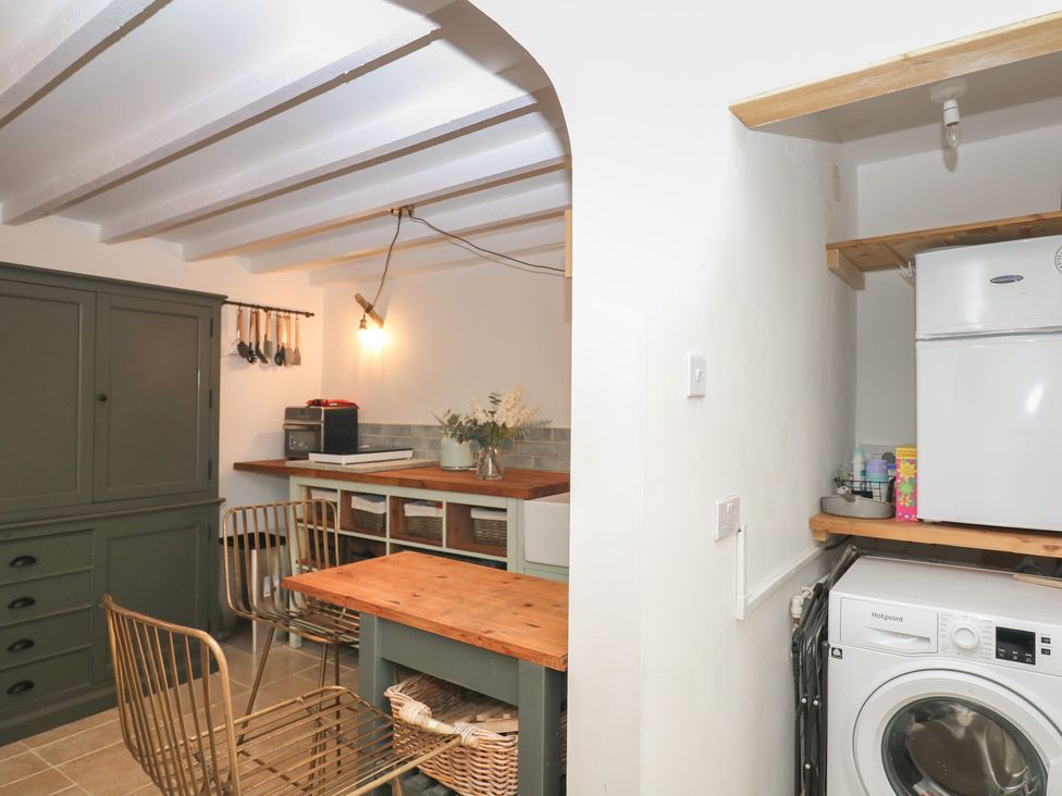 A kitchen with a dining table and appliances at Bedford Cottage in Yelverton