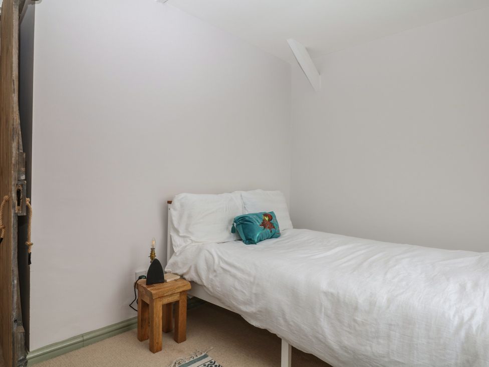 A bedroom with a bed and bedside table at Bedford Cottage in Yelverton