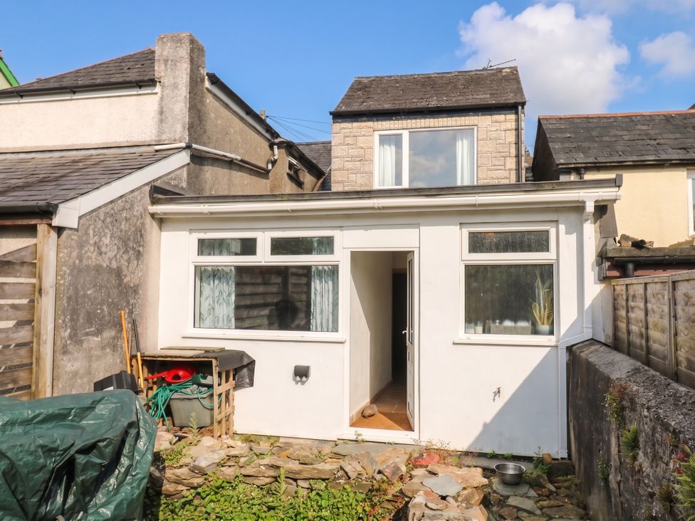 An outdoor view of a building with windows and a stone pathway at Bedford Cottage in Yelverton