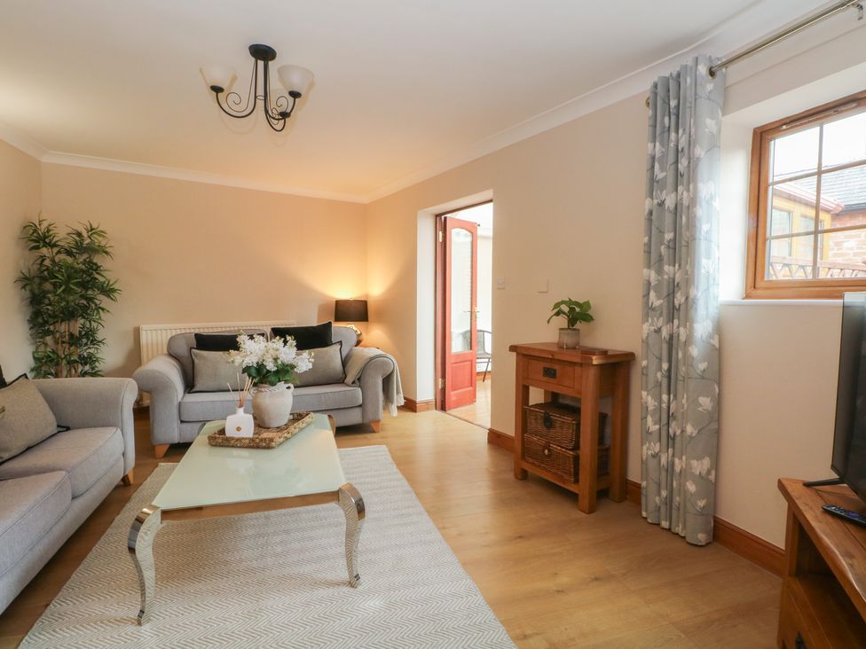 A living room with a sofa and table at 1 The Stables in Wrexham