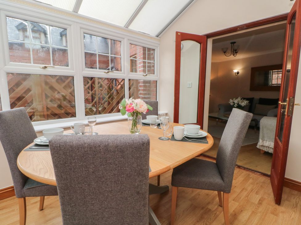 A dining room with a round table and chairs at 1 The Stables, Wrexham