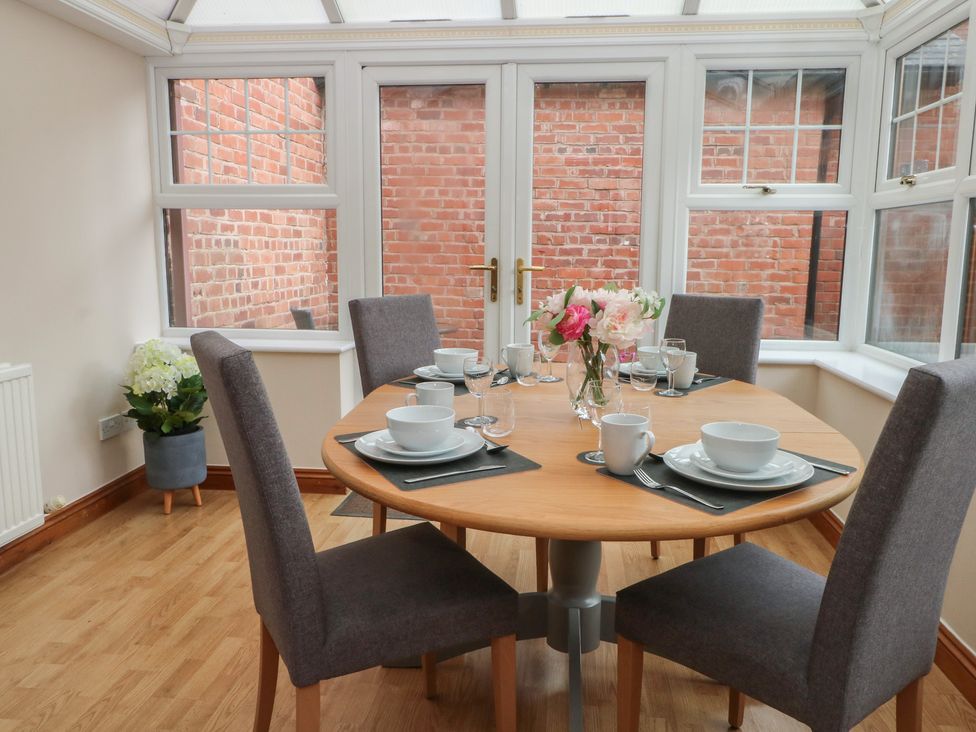 A dining table set with dishes and flowers at 1 The Stables, Wrexham