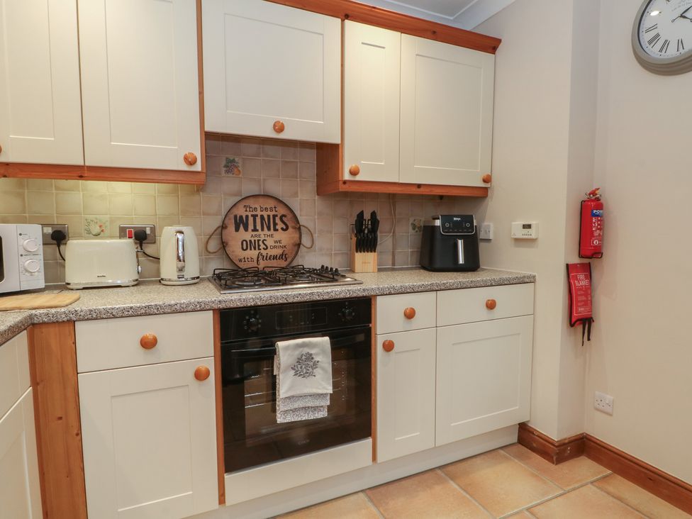 A kitchen with cabinets and appliances at 1 The Stables in Wrexham