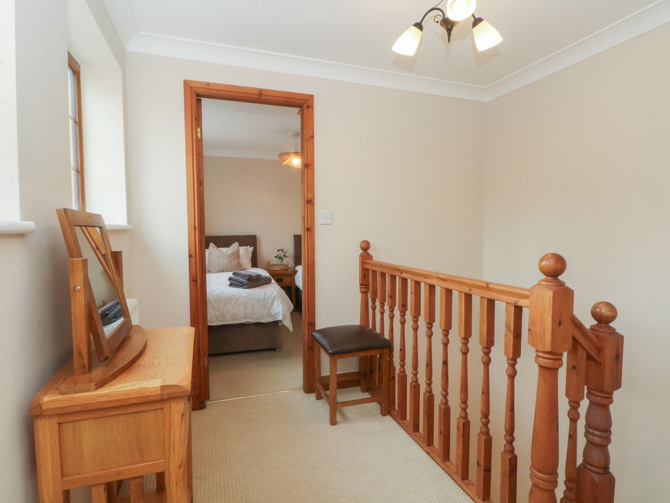 A landing with a chair and mirror at 1 The Stables Wrexham