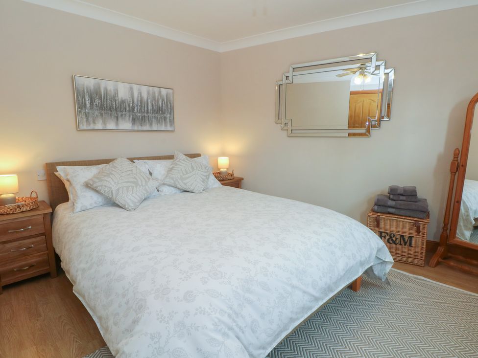 A bedroom with a bed and dresser at 1 The Stables, Wrexham