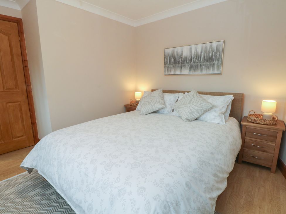 A bedroom with a bed and bedside tables at 1 The Stables in Wrexham