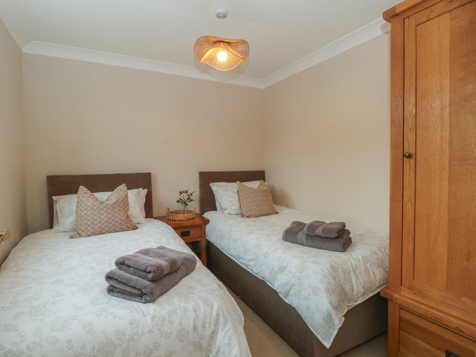 A bedroom with twin beds and a wardrobe at 1 The Stables Wrexham