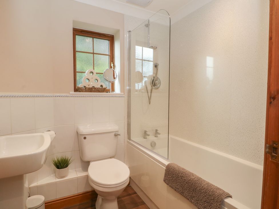 A bathroom with a bathtub, sink, and toilet at 1 The Stables in Wrexham