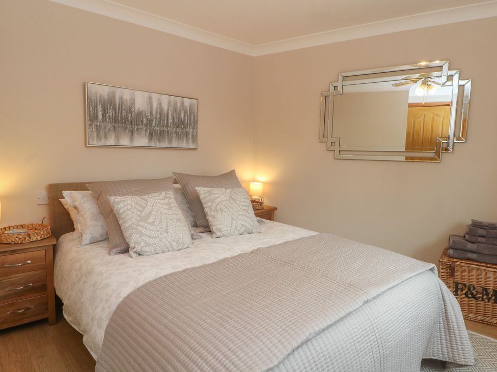 A bedroom with a bed and bedside tables at 1 The Stables Rossett