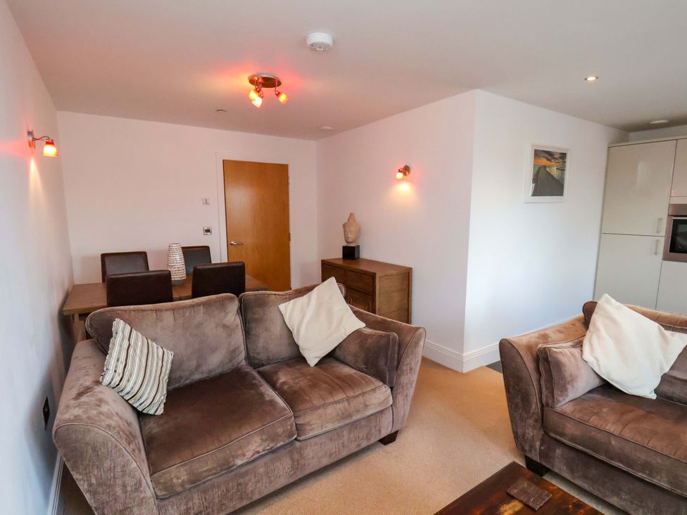 A living room with a sofa and dining area at Apartment 12