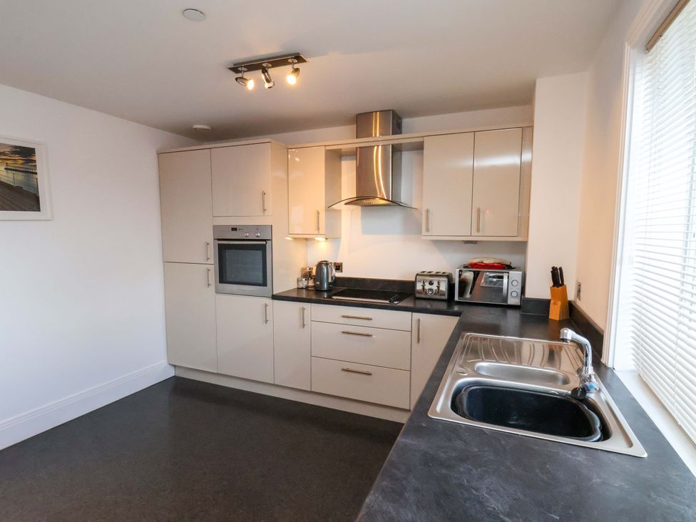 A kitchen with appliances and cabinets at Apartment 12 
