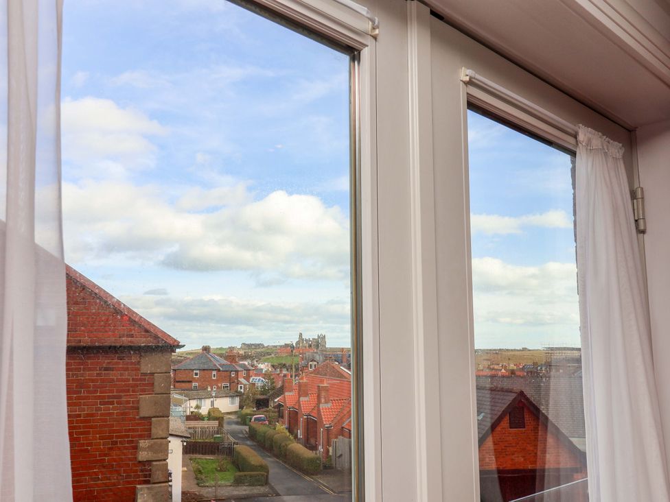 A view through a window showing rooftops and a cloudy sky at Apartment 12 in 