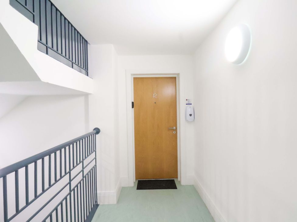 A hallway with a door numbered 12 at Apartment 12 